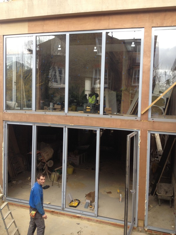 Aluminium bi-fold doors with two-storey glazing in Raynes Park