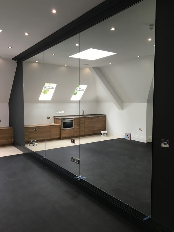Frameless glass partition in loft conversion by Raynes Park glaziers