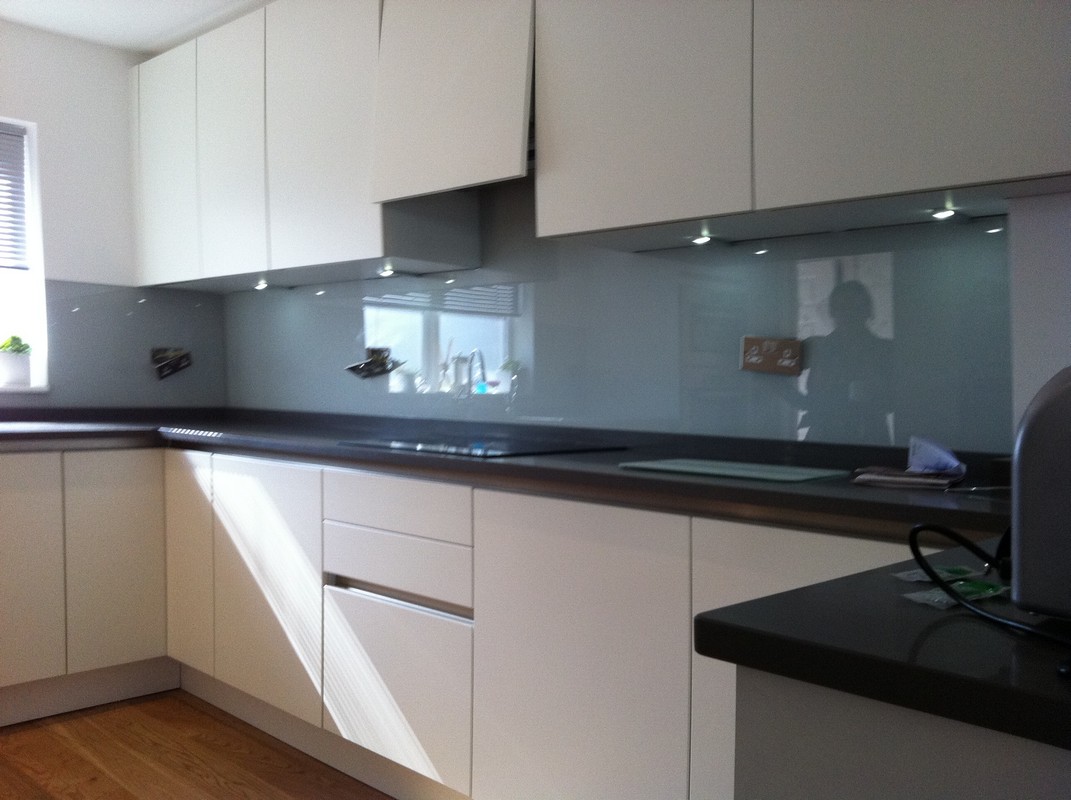 Grey glass kitchen splashback with LED lighting in Raynes Park
